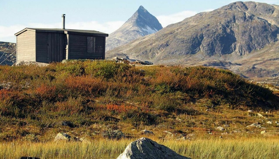 På Inatur kan du leie hytter i spektakulære omgivelser i nasjonalparkene våre. Denne hytta i Jotunheimen ligger ved Trollsjøen . Falketind og Uranostind i bakgrunnen.