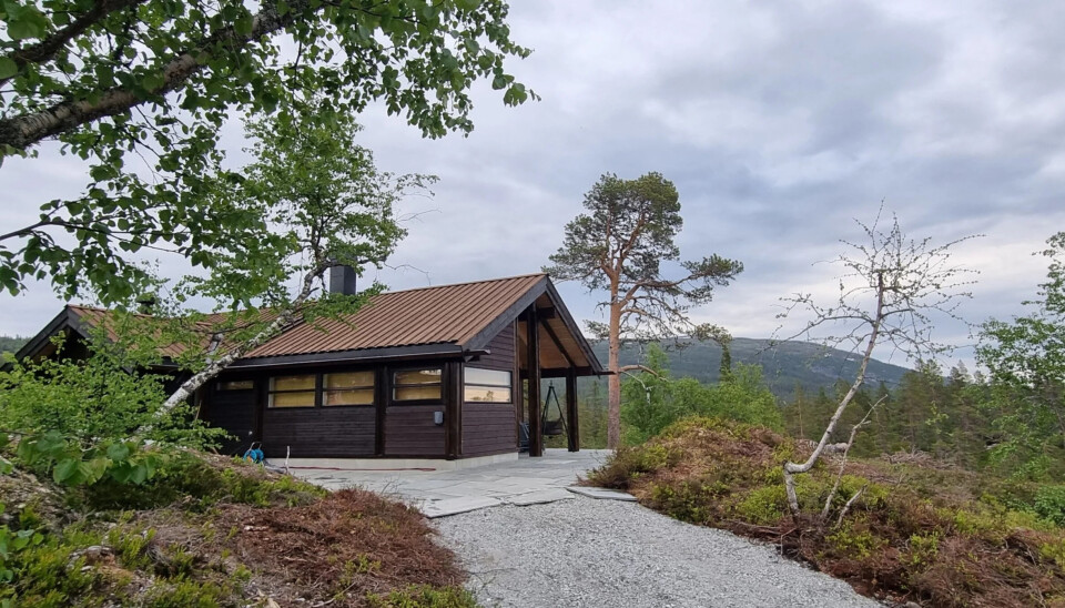 Den moderne hytta har vinduer i alle retninger og ligger i et flott fjellområde.