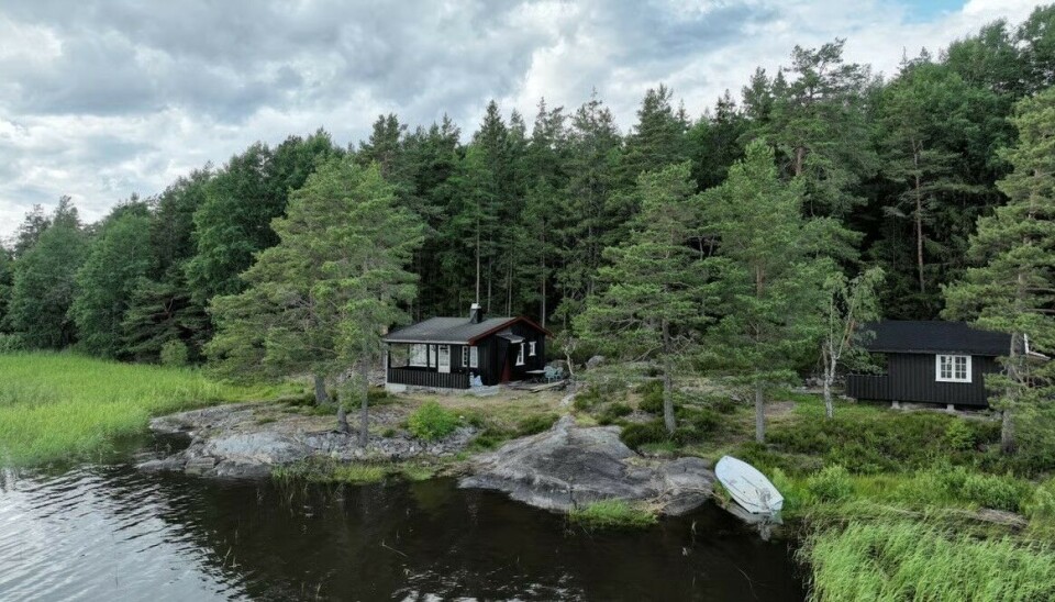 Nybygget badstue, svaberg og sjø.